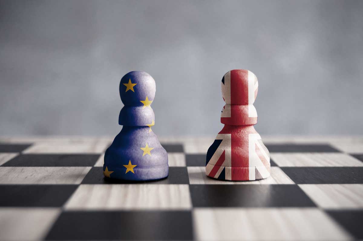 Zwei Schachfiguren mit Europa und UK Flagge